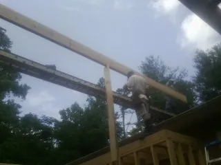 Carpenter setting a ridge beam over a new addition frame — Ice Dam Removal by Roofing Brothers in Brilliant
