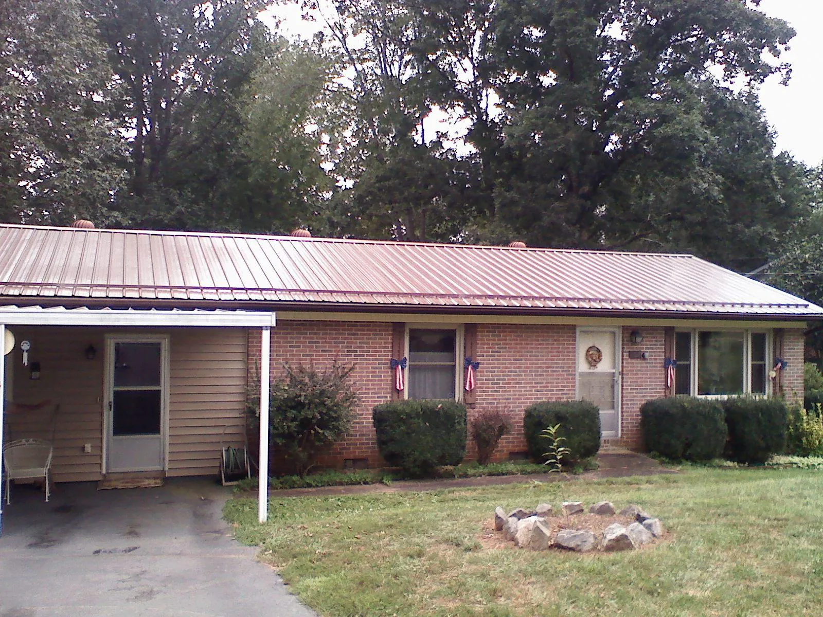 Bronze metal roof and carport on a brick ranch home — Roof Repair work by our crew in Brilliant