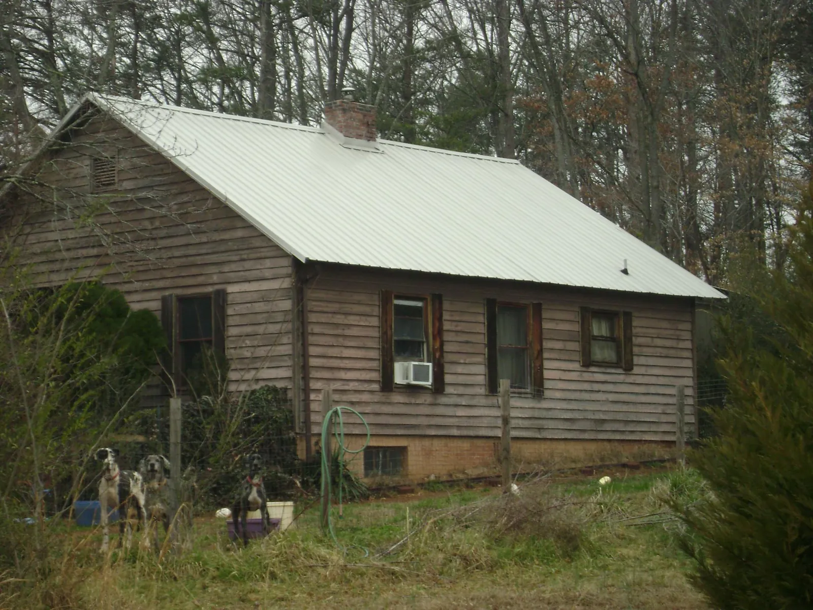 White metal roof on an old wood sided farmhouse, from a Metal Roof Installation job in Brilliant
